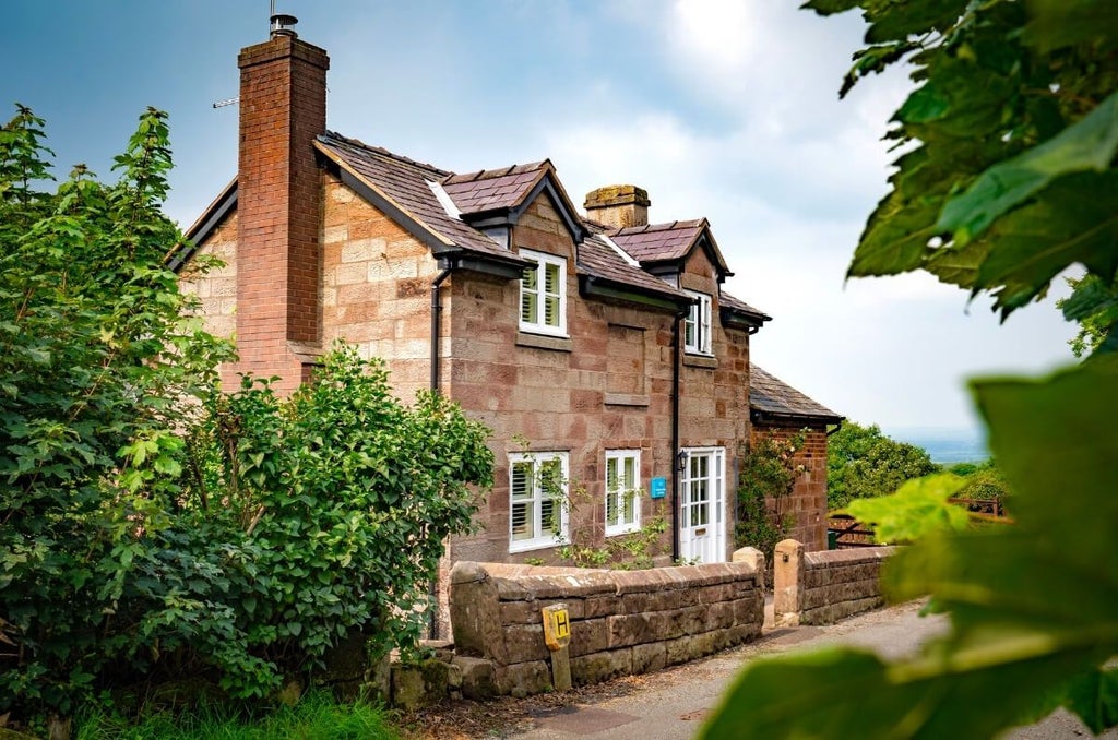 Charming countryside hotel with stone exterior, nestled in lush green landscape, showcasing traditional British hospitality and rustic elegance of The Scenset Inn