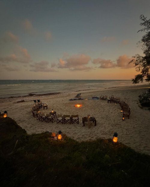 Luxurious beachfront resort nestled along Kenya's pristine coastline, featuring white sandy shores, swaying palms, and elegant thatched-roof accommodations with ocean views.