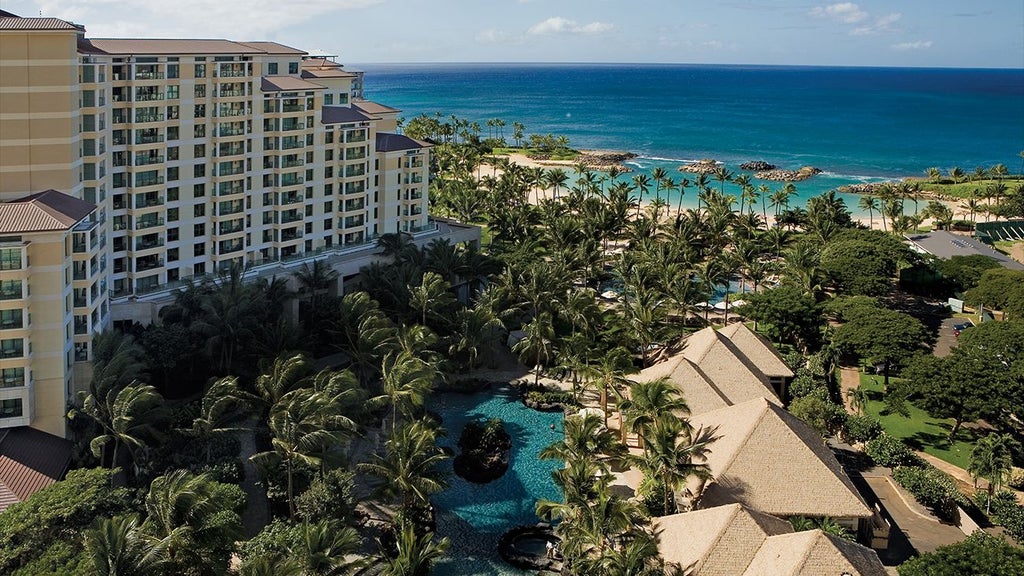 Luxurious beachfront resort with tropical palm trees, azure waters, and modern Hawaiian-style architecture at scenic Ko Olina coastline in Oahu, Hawaii