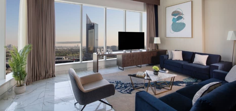 Modern duplex apartment with sleek design, spacious living area, floor-to-ceiling windows overlooking Dubai skyline, contemporary furnishings in neutral tones