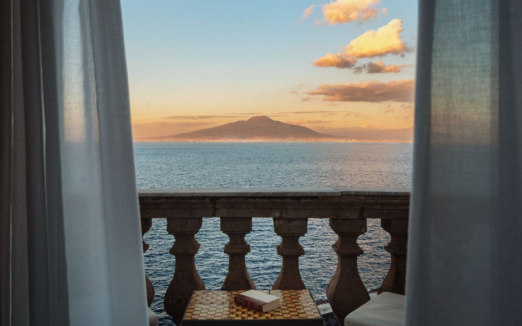 Luxurious cliffside hotel overlooking the azure waters of the Amalfi Coast, with elegant white architecture and Mediterranean terrace at sunset