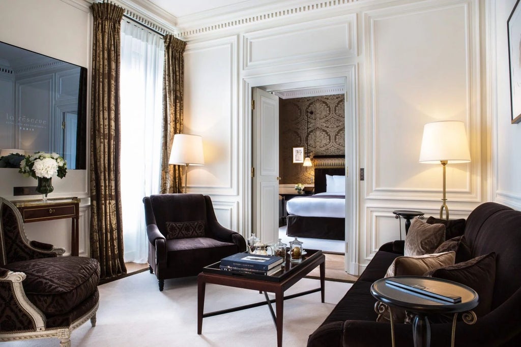 Opulent Parisian deluxe suite with elegant cream and gold decor, plush king bed, marble bathroom, and panoramic city views through expansive windows