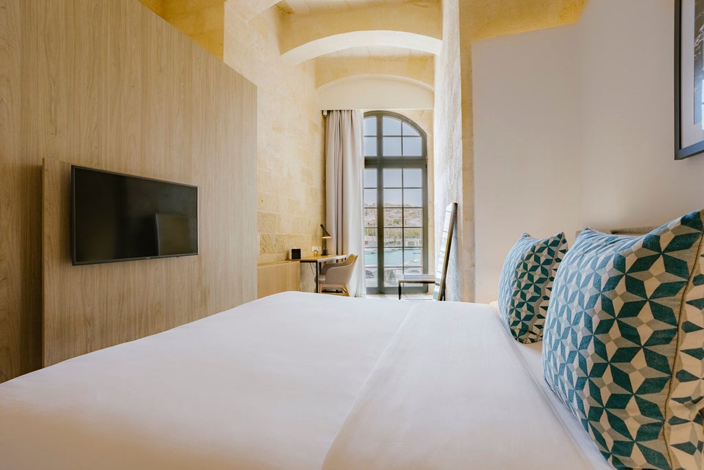 Luxurious Grand Harbour Suite with elegant contemporary design, panoramic sea views, and minimalist decor overlooking historic Maltese harbour landscape