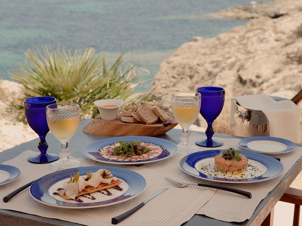 Luxurious stone fortress hotel Cap Rocat perched on Mallorca cliffside, featuring Mediterranean views and elegant terraced architecture