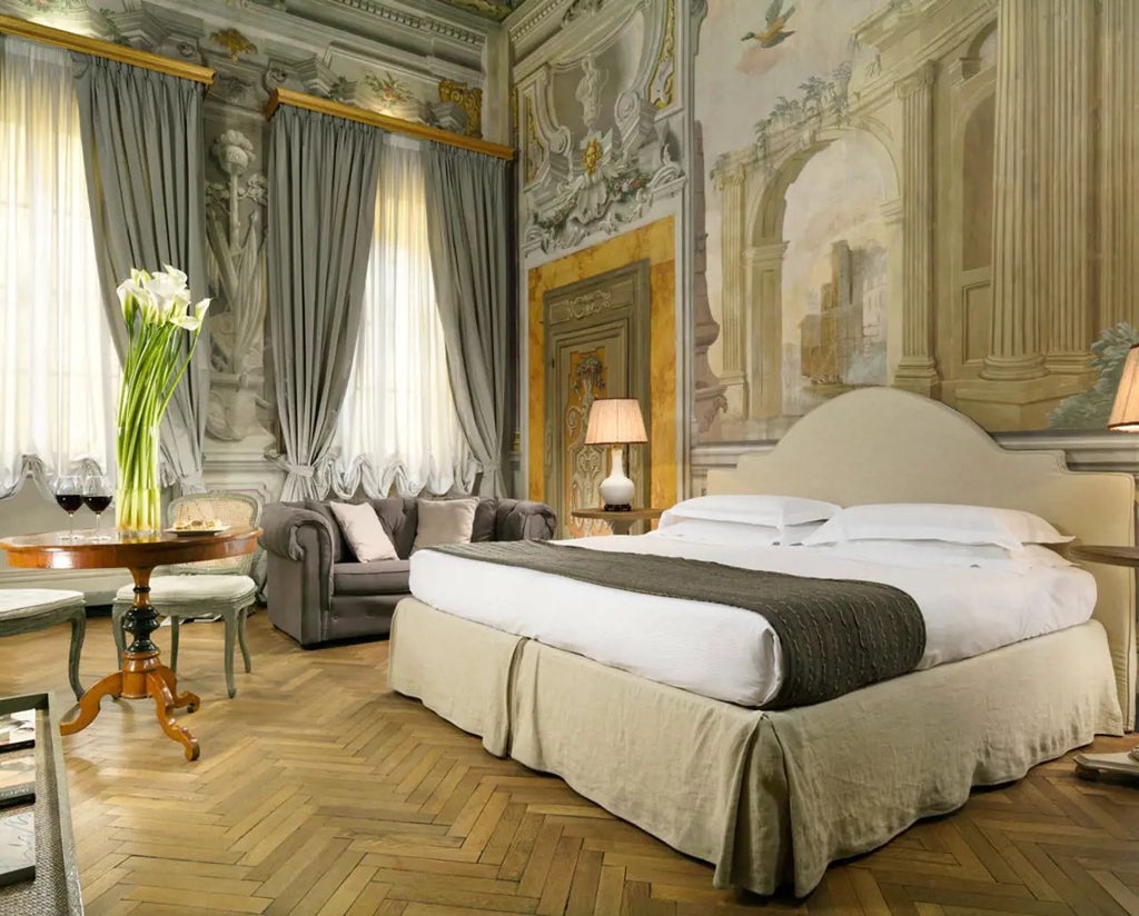 Elegant Prestige Room at Palazzo di Camugliano, featuring ornate antique furnishings, high ceilings, and classic Italian architectural details in soft neutral tones