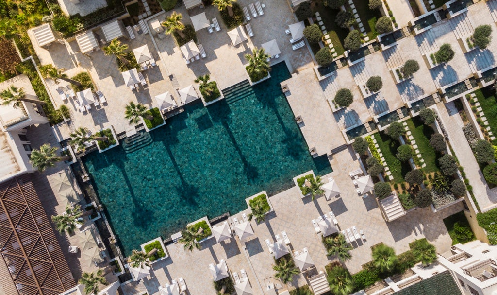 Luxurious beachfront Four Seasons hotel in Tunis with white Mediterranean architecture, palm trees, and infinity pools overlooking the sea