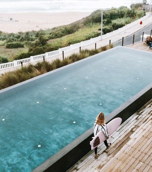 Modern beachfront villa with sleek white architecture, minimalist design, and panoramic ocean view at scenic coastal resort in Portugal.