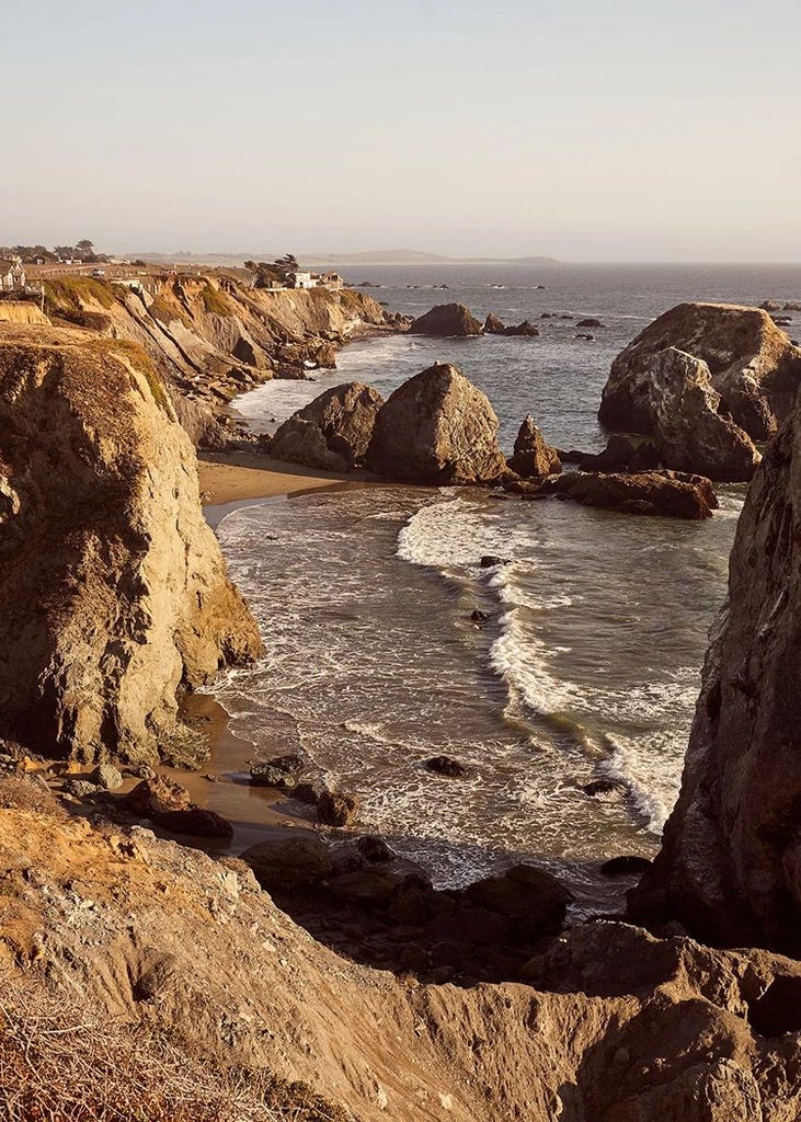 Luxurious coastal lodge nestled in Bodega Bay, featuring rustic wooden architecture, expansive windows, and breathtaking ocean views at sunset