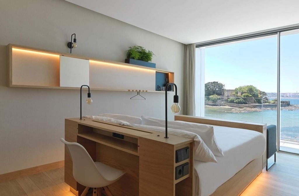 Elegant classic hotel room at NOA Boutique Hotel with pristine white linens, wooden floors, and minimalist Spanish design highlighting contemporary comfort.