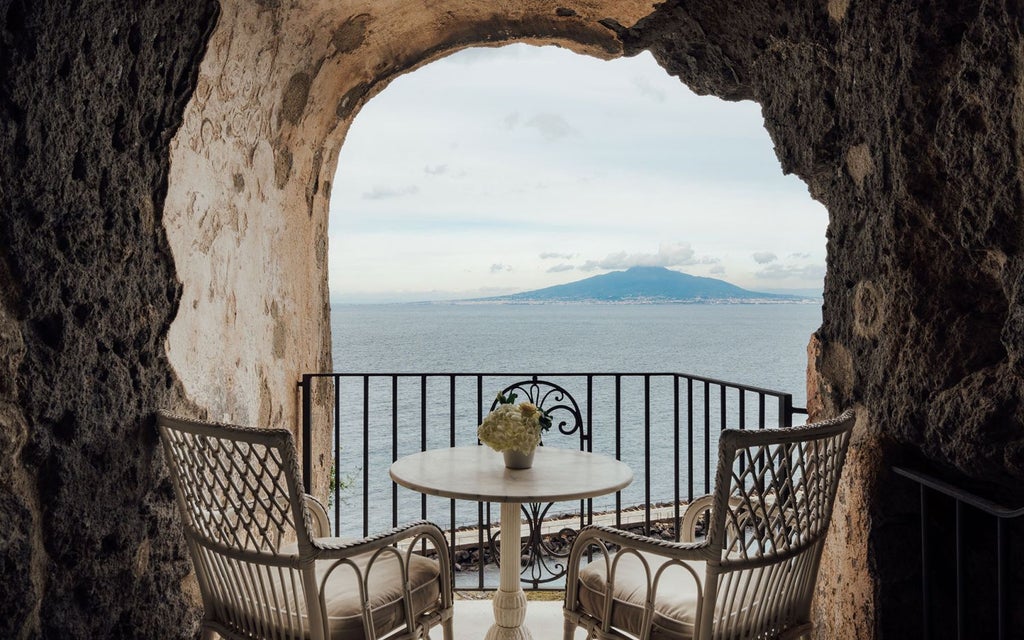 Luxurious seaside hotel perched on a cliff overlooking the Bay of Naples, with elegant Mediterranean architecture and stunning blue waters of Sorrento's coastline