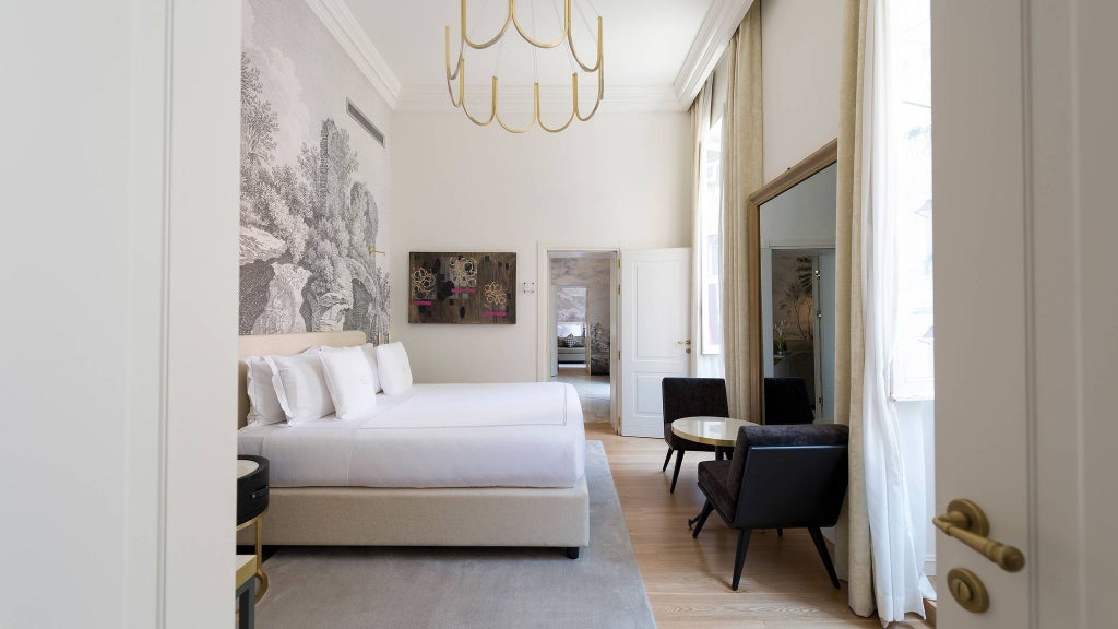 Luxurious grand suite with elegant Italian design, featuring plush king bed, marble bathroom, and expansive city view of Rome's historic skyline