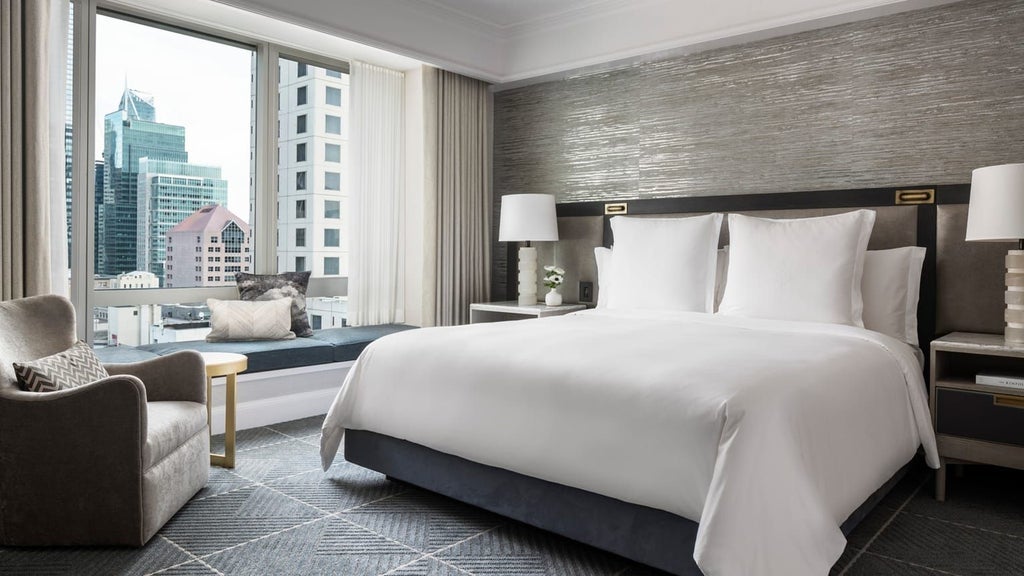 Elegant deluxe hotel suite with panoramic city views, plush king bed, modern marble bathroom, and contemporary furnishings at prestigious urban luxury hotel