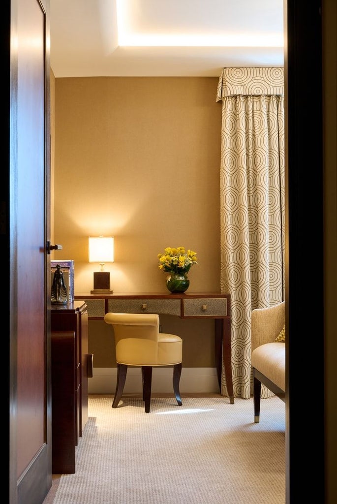 Elegant classic hotel room at scenset Mayfair with plush king bed, rich mahogany furniture, soft neutral color palette, and refined British design details