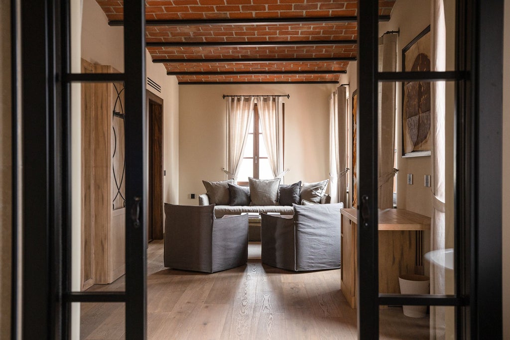 Elegant minimalist hotel room with soft natural light, sleek wood furnishings, plush white bedding, and expansive garden piano view at Nordelaia Resort, Italy