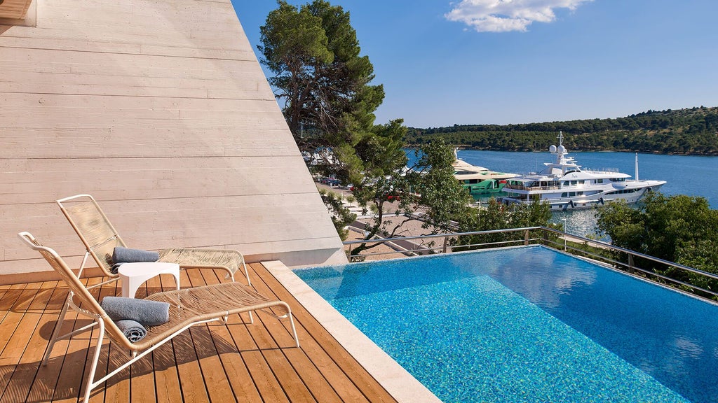 Modern luxury villa bedroom with panoramic sea view, minimalist design, wooden floors, and floor-to-ceiling windows overlooking Adriatic coastline in Šibenik, Croatia