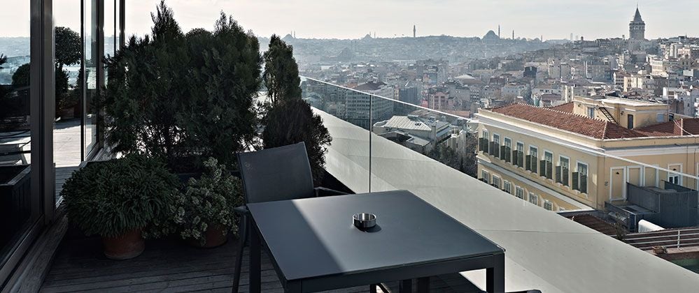 Spacious queen bedroom at Witt Istanbul Hotel with panoramic city views, elegant terrace, modern Turkish decor, and soft natural lighting