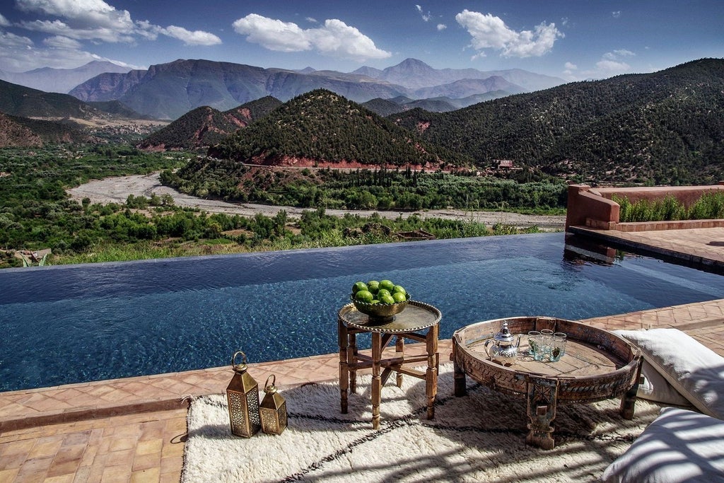 Luxurious Moroccan hotel nestled in Atlas Mountains, featuring traditional clay architecture, infinity pool and panoramic valley views