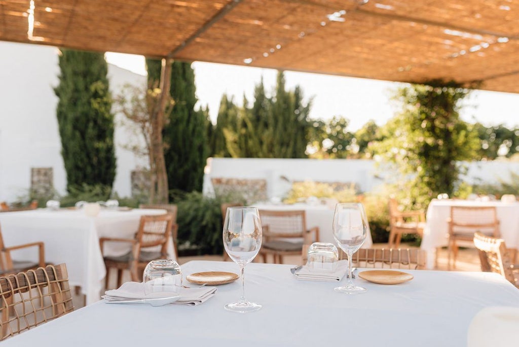 Luxury stone-walled Torralbenc hotel nestled in Menorca's scenic landscape, with rustic Mediterranean charm and elegant whitewashed architecture