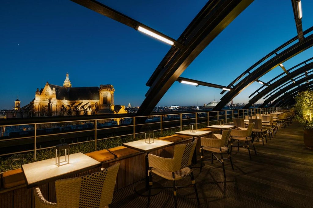 Contemporary French luxury hotel with arched windows, elegant stone facade, and ornate wrought-iron balconies in classic Parisian style