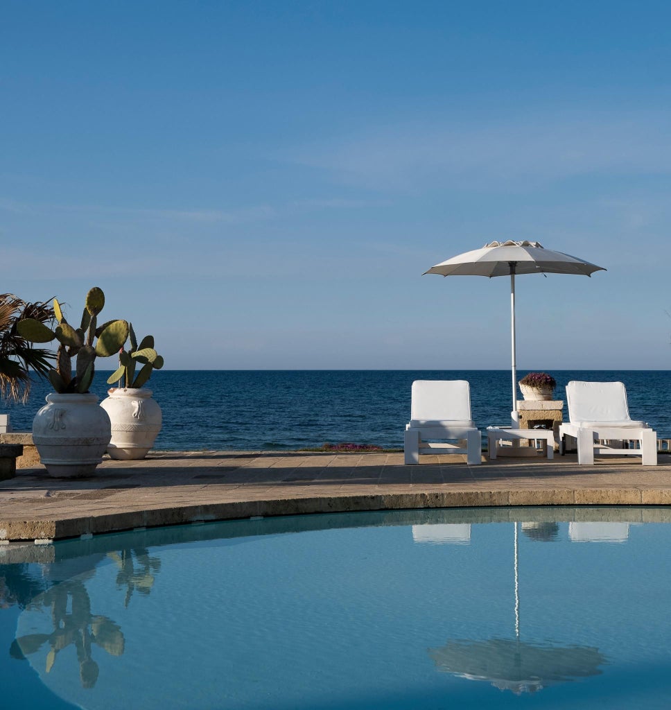 Spacious white-themed junior suite with minimalist design, premium furnishings, and elegant coastal Italian decor at Scenset Bianche Lifestyle Hotel