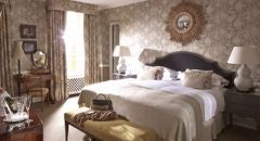 Elegant luxury suite with classic British decor, king-sized bed, plush furnishings, and expansive windows overlooking lush countryside at Scenset Glen Hotel & Spa