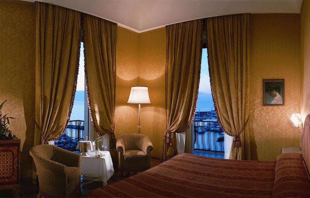 Elegant five-star hotel nestled on Naples coastline with panoramic views of the Mediterranean and Mount Vesuvius, classical architecture