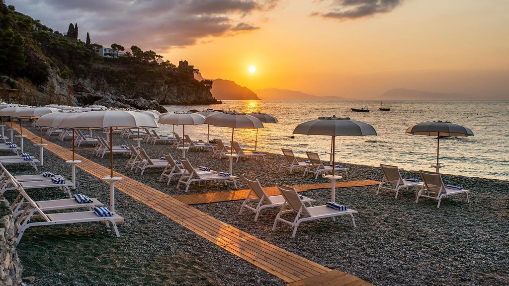 Luxurious white hotel built into Amalfi Coast cliffside, with terraced gardens and panoramic balconies overlooking Mediterranean Sea