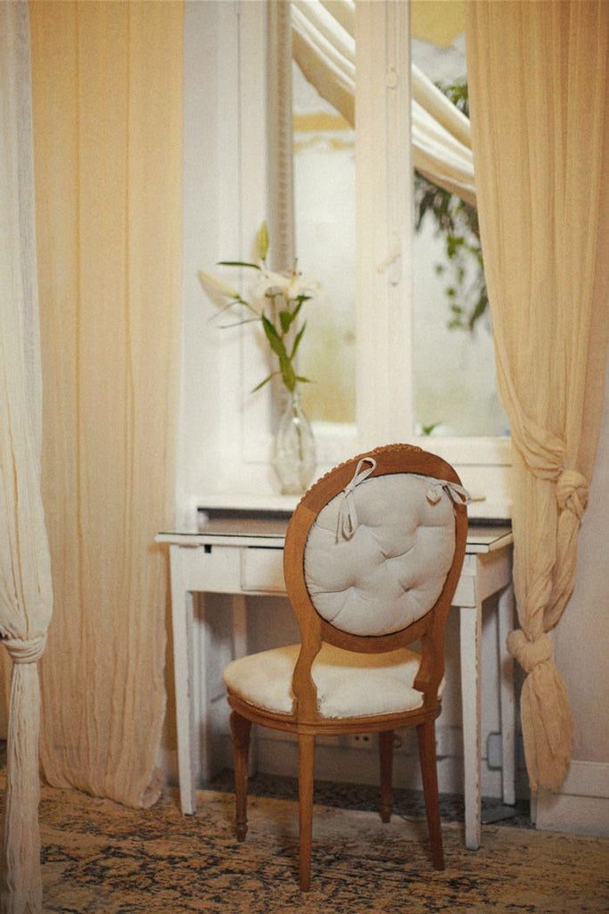 Elegant garden-view hotel room with minimalist design, soft neutral tones, plush white bedding, and lush greenery visible through large windows at Scenset Athens retreat