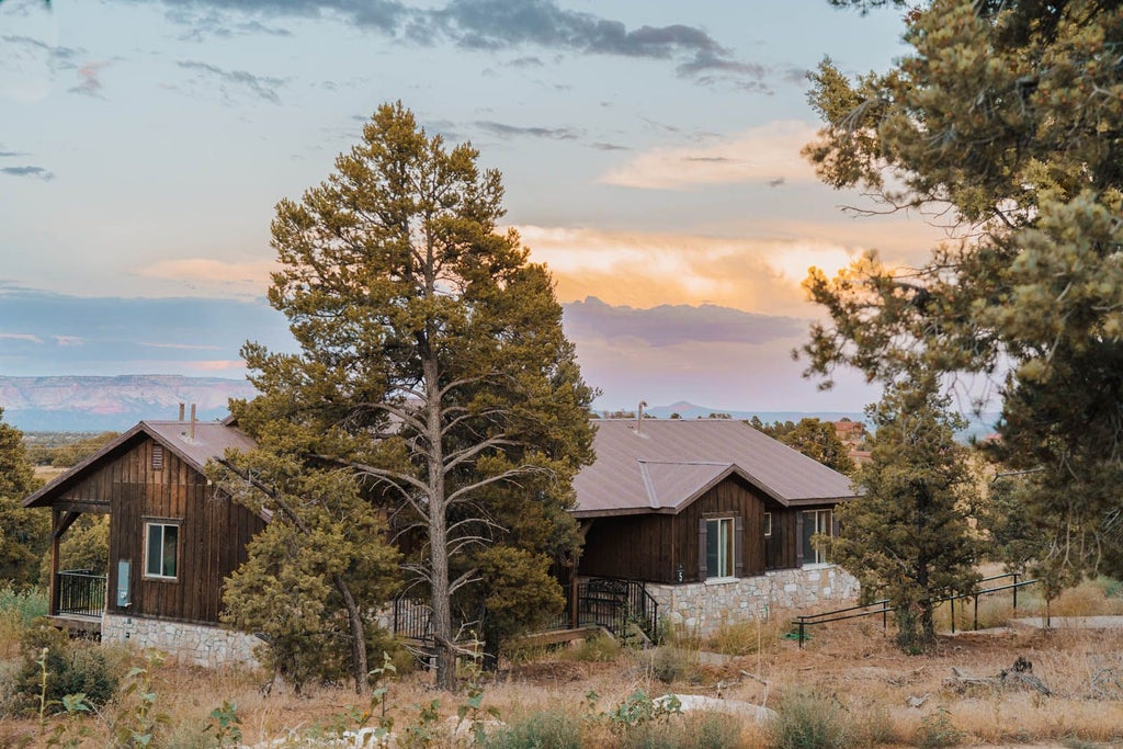 Rustic lodge bedroom with wooden furnishings, warm earth tones, and panoramic mountain views at Scenset Mountain Ranch, capturing serene wilderness accommodation