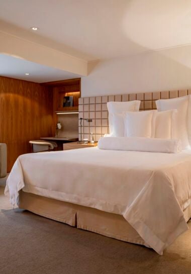 Elegant deluxe king hotel room with modern Brazilian design, soft neutral tones, plush bedding, and sleek minimalist furnishings in São Paulo luxury hotel