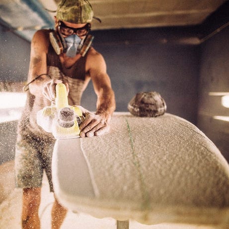 Fiberglass being formed into a longboard