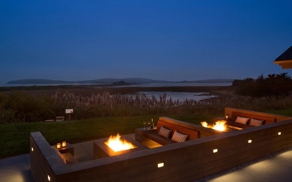 Rustic coastal lodge nestled among pine trees, with expansive wooden deck overlooking misty Bodega Bay shoreline at sunset, embodying serene California coastal elegance