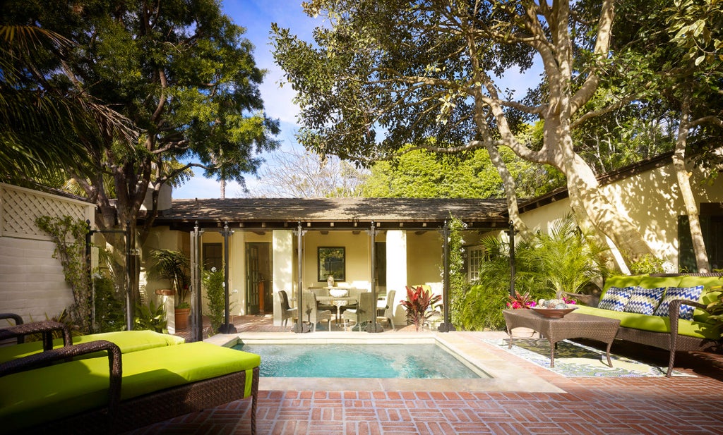 Spanish colonial-style luxury resort with white stucco walls and terracotta roofs nestled among palm trees along Santa Barbara's coastline