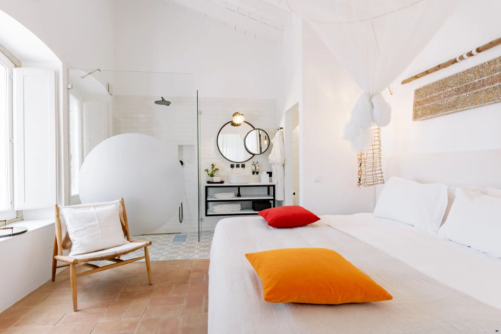 Elegant superior suite with soft neutral tones, plush white bedding, wooden floors, and modern minimalist design overlooking scenic Portuguese landscape