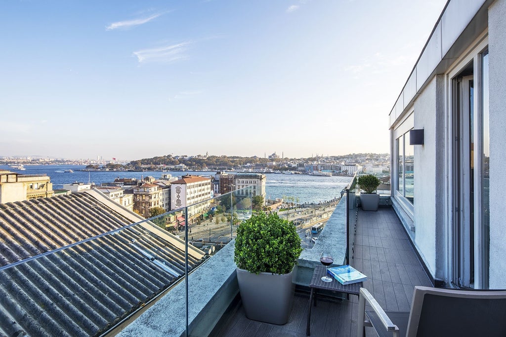 Luxurious penthouse suite with panoramic city views, featuring elegant modern decor, plush king bed, and expansive windows overlooking Istanbul's skyline