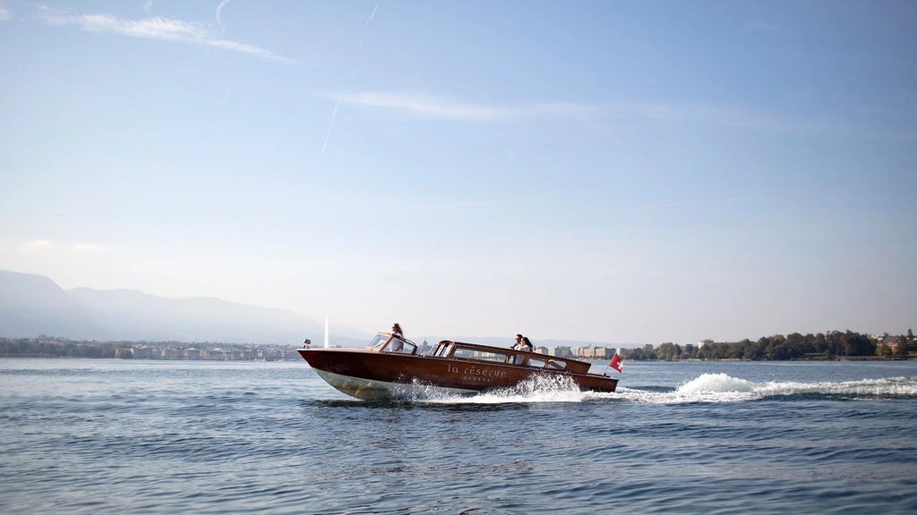 Luxurious lakeside hotel with modern glass architecture, panoramic views of Lake Geneva and Swiss Alps, elegant spa retreat nestled in scenic landscape