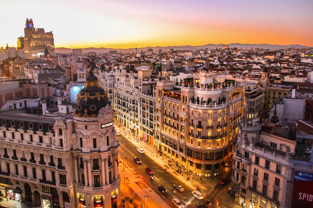 High-end cityscape of Madrid's Plaza Mayor, historic grand square surrounded by elegant baroque buildings with ornate facades at sunset