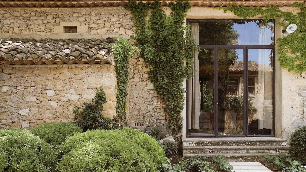 Elegant French stone hotel with pale yellow facade, lavender fields in foreground, terracotta roof, and traditional Provençal architectural charm at sunset