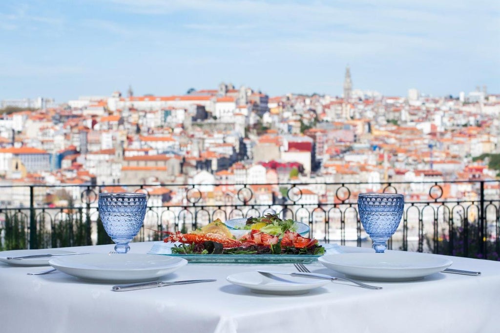 Luxurious infinity pool overlooking Porto's historic skyline at sunset, with terraced gardens and Douro River views at The Yeatman hotel