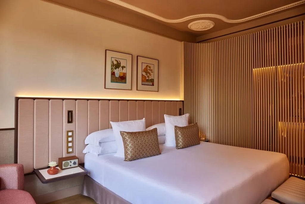 Elegant deluxe hotel room with contemporary design, plush white bedding, modern furniture, and expansive city view in central Spain's Grand Hotel