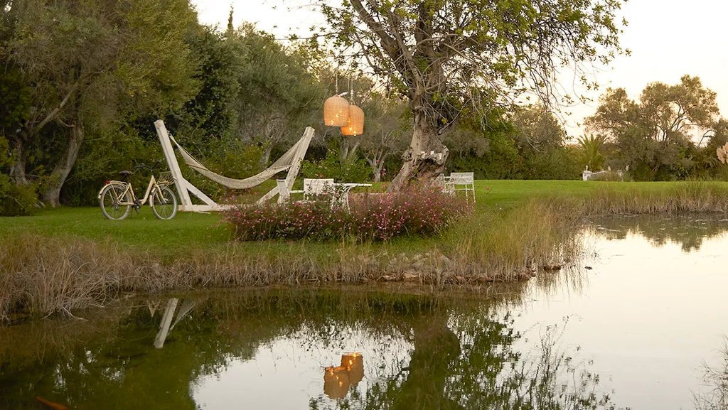 Luxury boutique hotel with whitewashed buildings, lush gardens, and traditional Algarvian architecture nestled in scenic Portuguese countryside.