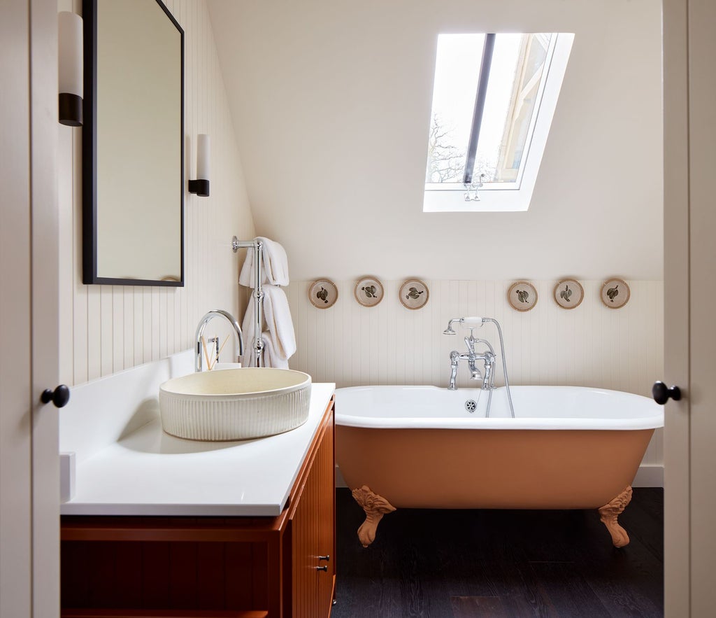 Elegant countryside suite with plush cream armchairs, soft natural lighting, and rustic wooden furniture in a luxurious boutique hotel room at Grove of Narberth