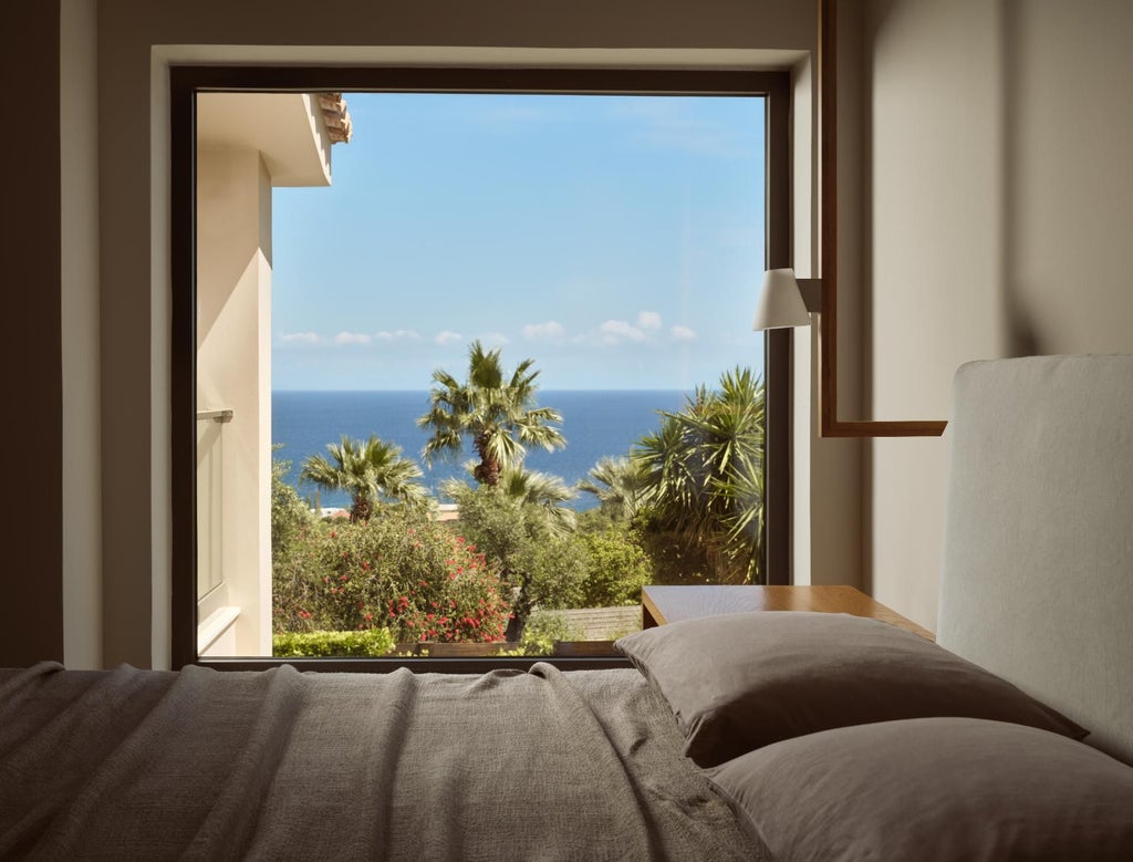 Luxurious white and blue villa bedroom in Greece with panoramic Aegean Sea view, elegant minimal design, and private balcony overlooking coastal landscape