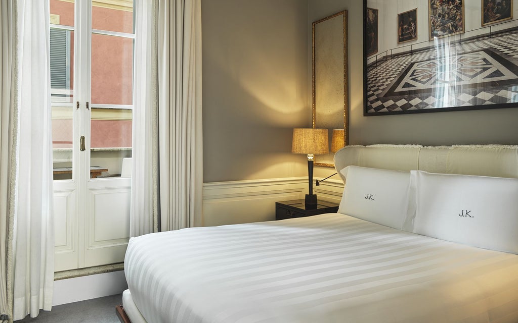 Elegant Italian luxury hotel room with plush cream furnishings, rich wood accents, and soft ambient lighting in a sophisticated, minimalist design