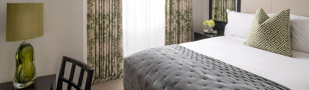 Elegant cozy hotel room at The Scenset hotel in the United Kingdom, featuring soft neutral tones, plush bedding, and sophisticated minimalist decor.