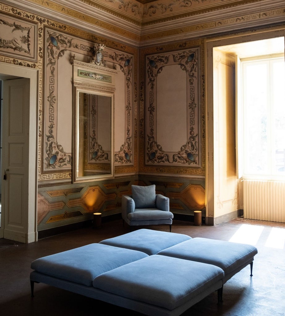 Opulent master suite at Palazzo Daniele, featuring minimalist design, high ceilings, antique furnishings, and elegant neutral tones with ornate architectural details