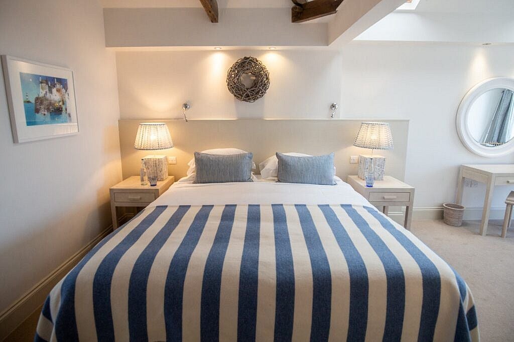 Cozy village room with sea-view window, nautical-inspired decor, crisp white linens, and coastal Cornwall charm at a boutique hotel in St Mawes