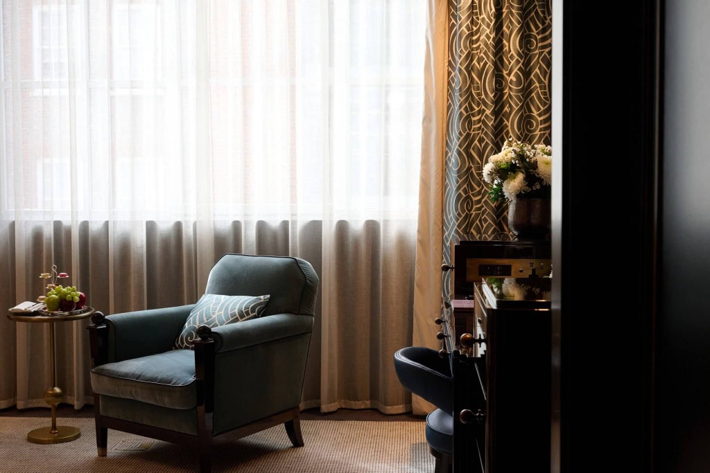 Elegant superior grand room at scenset Hotel in Mayfair, London, featuring plush king bed, rich oak furnishings, and soft neutral color palette with refined city view