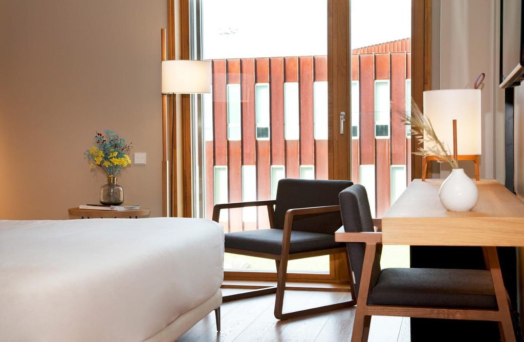 Minimalist, sunlit standard room at scenset Hotel & Spa, featuring sleek wooden furnishings, crisp white linens, and panoramic view of Spanish landscape