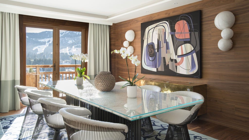 Luxurious alpine hotel Four Seasons Megeve nestled in snowy French mountains, featuring stone and timber facade with warm glowing windows